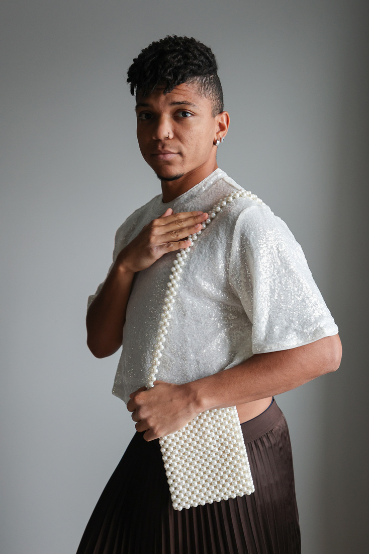 Man in Gender-Fluid  Fashion Wearing a Bag 